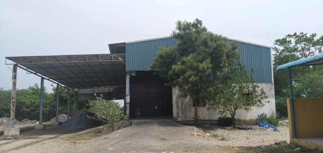 The plant shed from outside, a steel-framed building with an open loading bay.